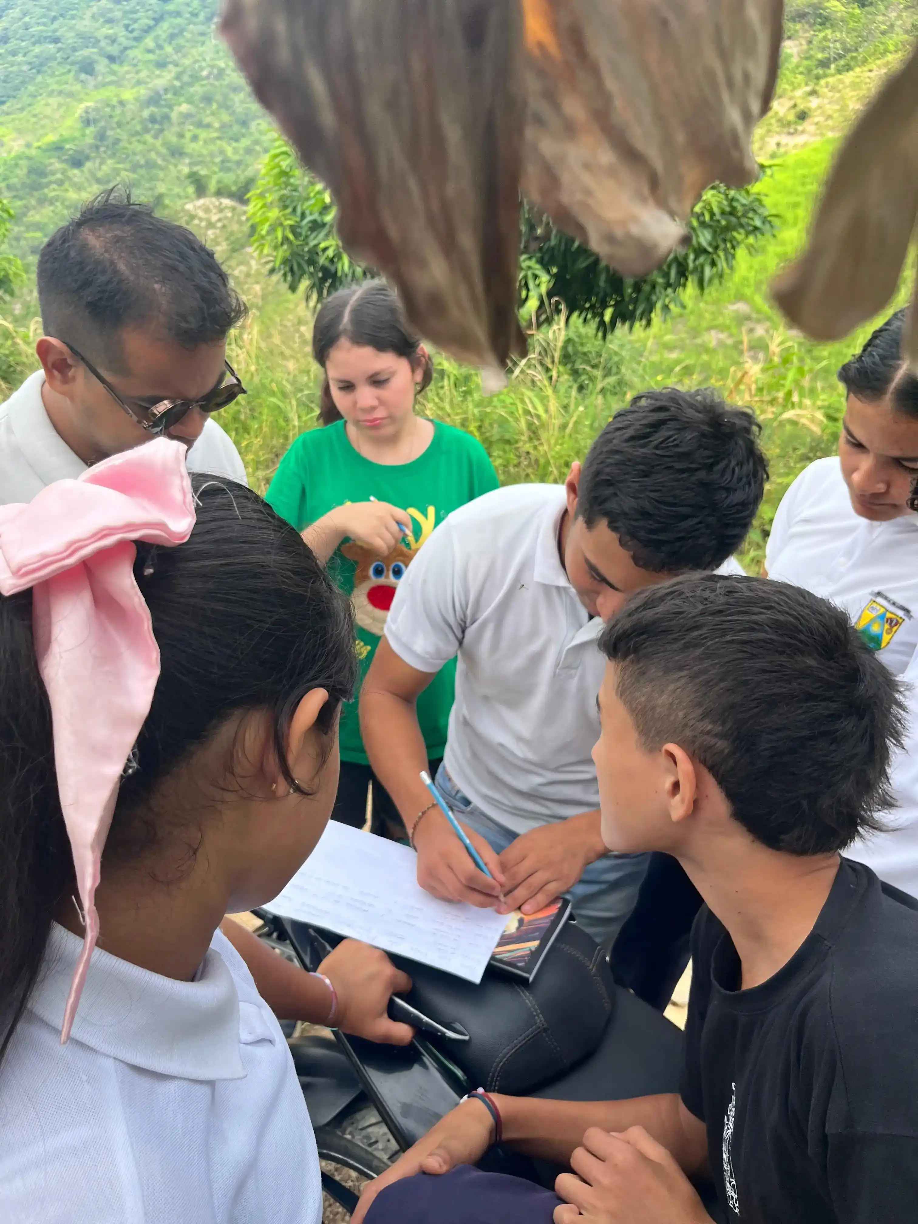 Estudiantes sistematizando observaciones de campo sobre una motocicleta en zona rural